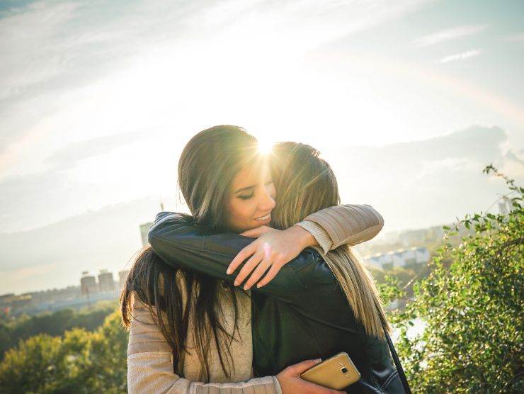 due ragazze che si abbracciano al tramonto