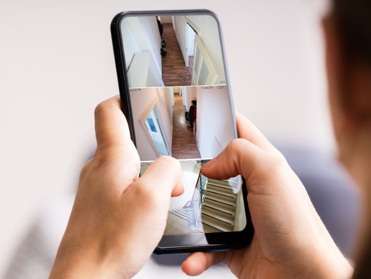 uomo controlla telecamere da smartphone