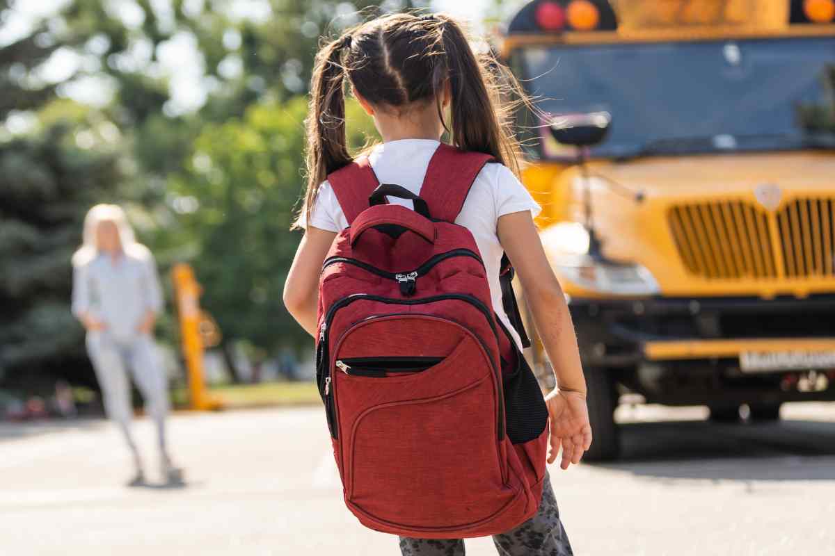 una bambina e uno scuola bus