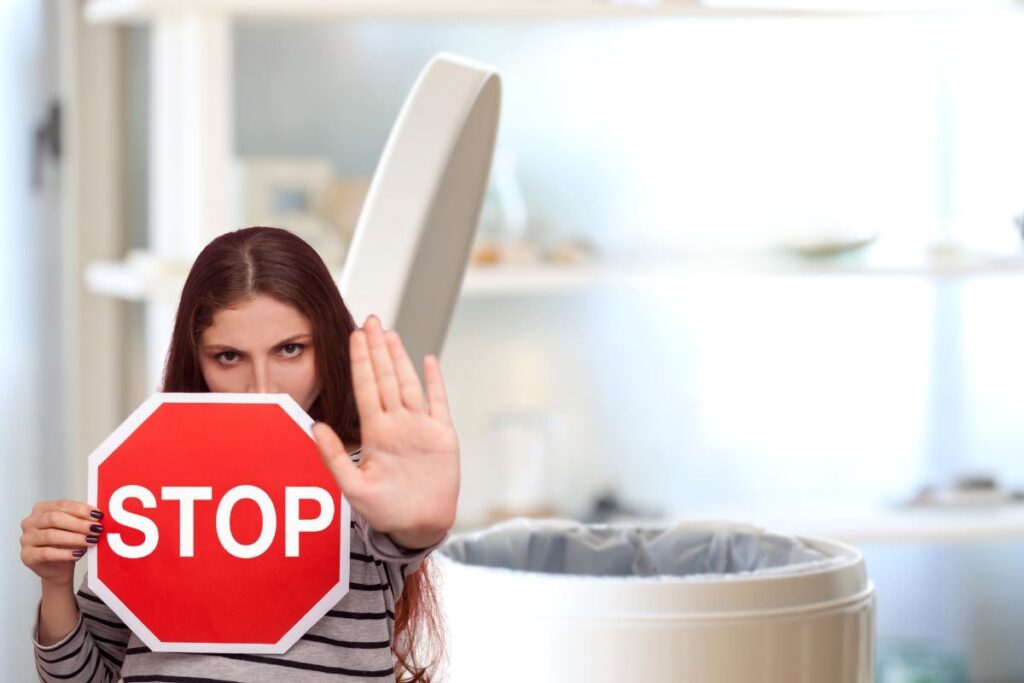 donna che dice stop e bidone della spazzatura