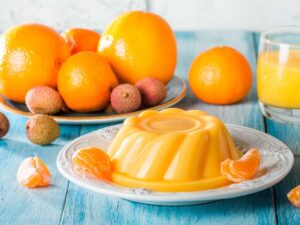 un budino in un piatto con arance fresche e lichi