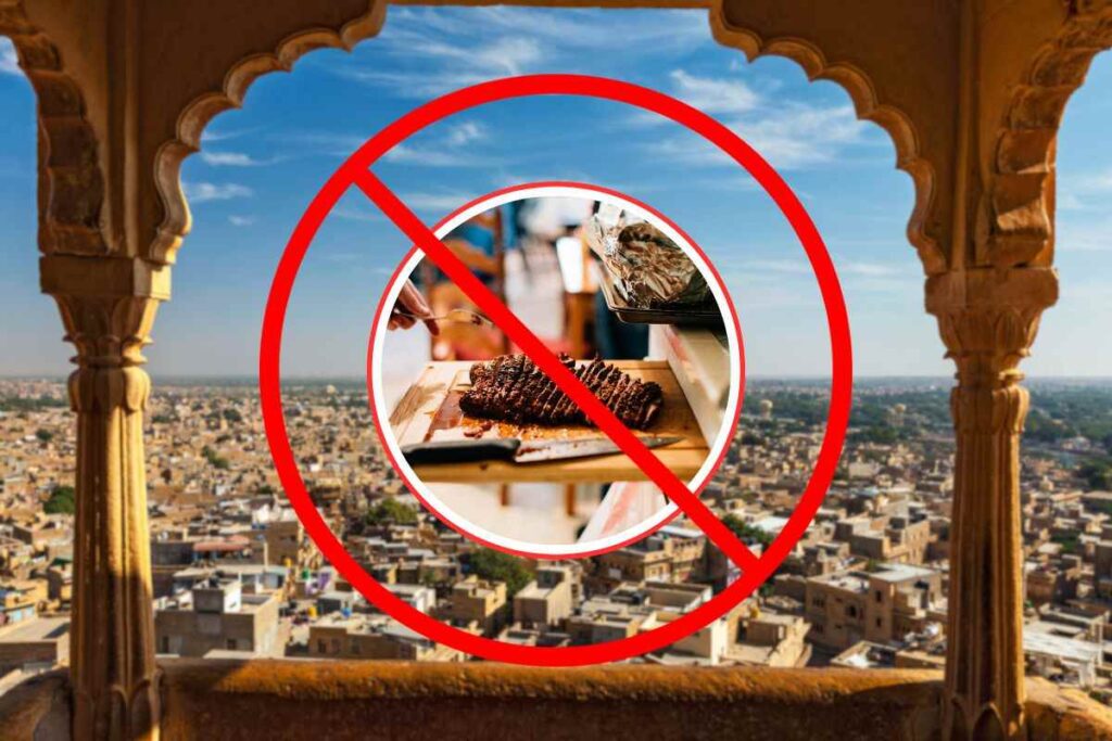 città indiana come sfondo e in primo piano una fetta di carne cotta e simbolo di divieto