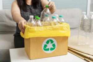 donna che ricicla bottiglie di plastica