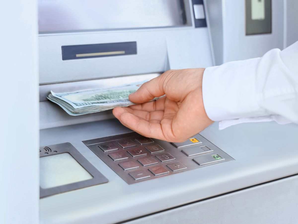 persona preleva banconote da un bancomat