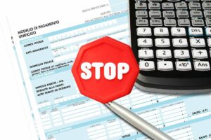 modello F24 da compilare, calcolatrice e scritta stop