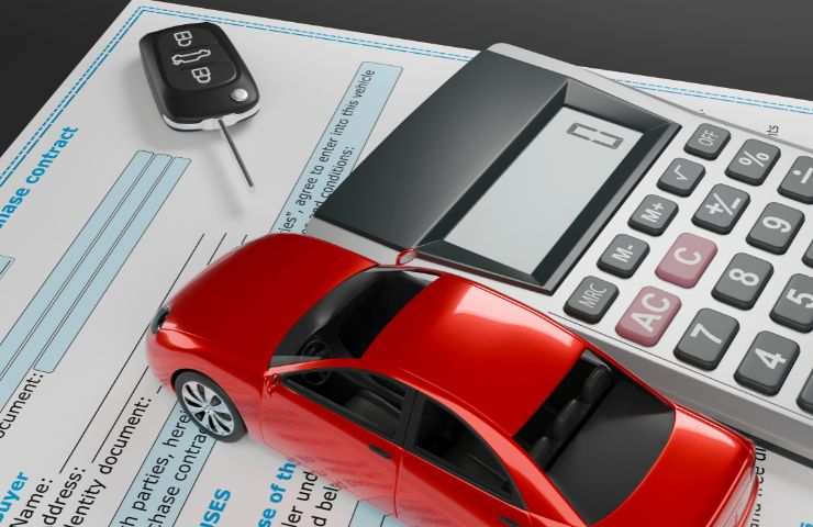 automobile in miniatura, calcolatrice e tassa da pagare