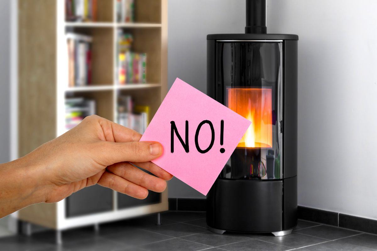 stufa a pellet e mano con postit su cui c'è scritto no